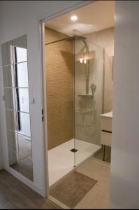 a shower with a glass door in a bathroom at Le Candle - Parking & Balcon - Muret - Toulouse in Muret