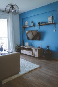 uma sala de estar azul com um sofá e uma televisão em Blue Touch Pervolia Paradise Near The Beach em Lárnaca
