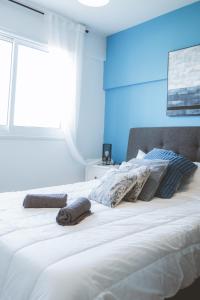 um quarto com uma grande cama branca com paredes azuis em Blue Touch Pervolia Paradise Near The Beach em Lárnaca