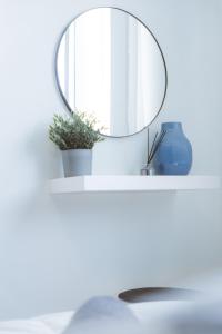 um espelho numa prateleira branca com um lavatório em Blue Touch Pervolia Paradise Near The Beach em Lárnaca