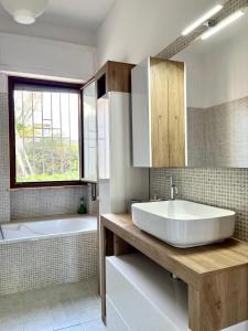 La salle de bains est pourvue d'une grande baignoire blanche et d'un lavabo. dans l'établissement Villa vista mare, à Santo Spirito