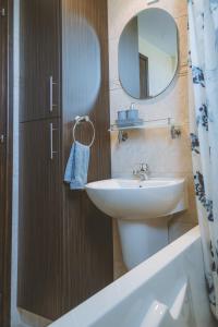 uma casa de banho com um lavatório e um espelho em Blue Touch Pervolia Paradise Near The Beach em Lárnaca