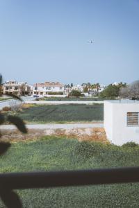 a view from a window of a yard with a building at Blue Touch Pervolia Paradise Near The Beach in Larnaca