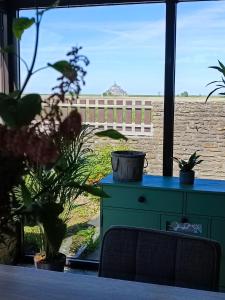 une chambre avec une table bleue et quelques plantes dans l'établissement Vue unique sur le Mont St Michel, à Huisnes-sur-Mer
