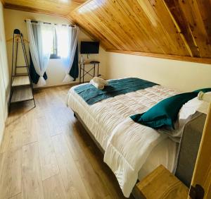 a bedroom with a large bed with a wooden ceiling at Au sommet des Salazes in Salazie