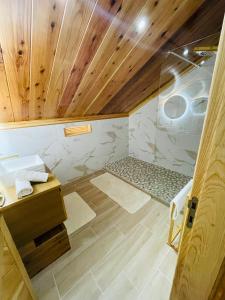 y baño con ducha y techo de madera. en Au sommet des Salazes, en Salazie