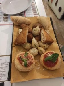 a plate of food with pizzas on a table at Casa Palinuro Vacanze in Palinuro