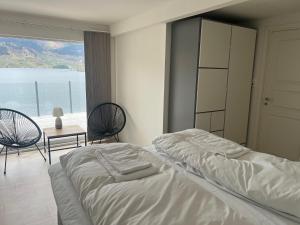 a bedroom with a bed and a view of the ocean at Trolltun, Frystevegen 4 in Ulvik