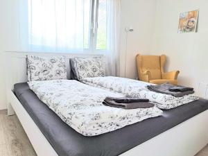 a bed with two sheets and a chair in a room at Garsónka v Bratislave in Bratislava