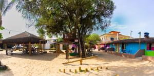 a playground in a town with a tree and buildings at Pousada Barari in Guarapari