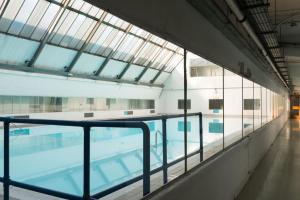 a large swimming pool with glass windows and a swimming pooliterator at Unique Flat with Pool in Trendy Peckham Area in London