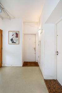 an empty hallway with white walls and a picture on the wall at Unique Flat with Pool in Trendy Peckham Area in London