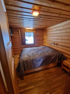 ein Schlafzimmer in einem Blockhaus mit einem Bett darin in der Unterkunft Ylläs Valokki in Ylläsjärvi