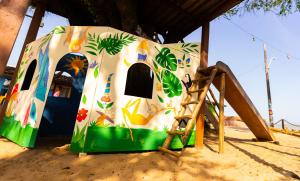 uma estrutura de brincar na areia ao lado de um parque infantil em Pousada Barari em Guarapari