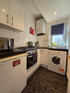 a kitchen with a washing machine and a washer at Great Flat Close to Edgware Road in London