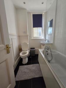 a bathroom with a toilet and a tub and a sink at Great Flat Close to Edgware Road in London