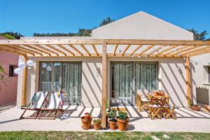 a wooden pergola with a table and chairs on a patio at Kumquart estate- Mandarin in Aspiotádes