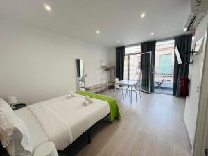 1 dormitorio blanco con 1 cama, mesa y sillas en Rainbow Apartments BY BLAUSITGES, en Sitges