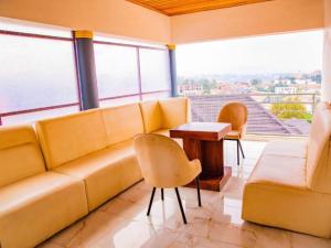 een woonkamer met een bank, stoelen en een tafel bij KEZA Home in Kigali