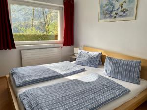 dwa łóżka w pokoju z oknem w obiekcie Stubai Apartment Telfes w mieście Telfes im Stubai
