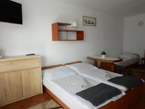 a bedroom with a bed and a table and a television at U Reginy in Jastrzębia Góra
