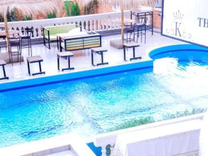 een zwembad met tafels en stoelen naast een restaurant bij KEZA Home in Kigali