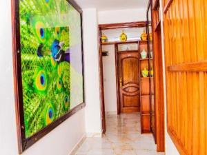 a hallway with a peacock painting on the wall at KEZA Home in Kigali