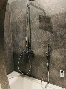 una ducha con una manguera pegada a la pared en Grand Apartments en Milán