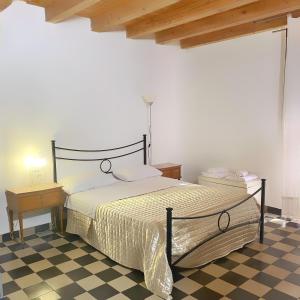 a bedroom with a bed and a checkered floor at Pantalica Rooms Affittacamere Sortino Siracusa in Sortino