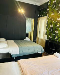 1 dormitorio con 2 camas y una planta en la pared en Grand Apartments en Milán