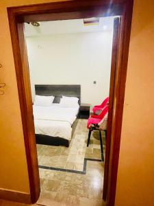 Habitación con vistas a un dormitorio con cama y espejo. en Hotel Highway Link en Karachi