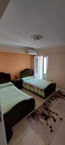 a bedroom with two beds and a rug at شاليه في قرية هيلو بيتش في الكيلو ٥٠ in Borg El Arab