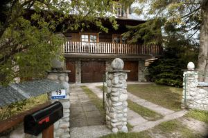 a house with a gate and a clock in front of it at Artist's House in Falsztyn