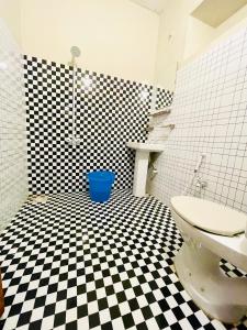 a bathroom with a black and white checkered floor at Hotel Highway Link in Karachi