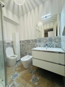 a bathroom with a toilet and a sink and a tub at Giulivi Assisi Apartments in Assisi