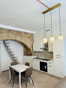 a kitchen with a table and chairs and a staircase at Giulivi Assisi Apartments in Assisi