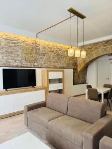 a living room with a couch and a stone wall at Giulivi Assisi Apartments in Assisi