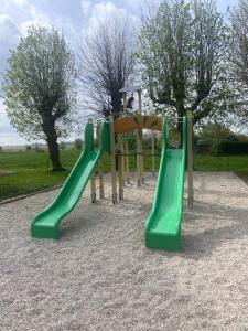 a playground with a green slide in a park at B&B la récré de Bauffe in Bauffe