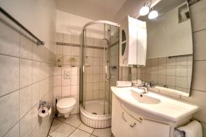 uma casa de banho com um lavatório, um chuveiro e um WC. em Strandhotel, App 1SH109 em Heiligenhafen