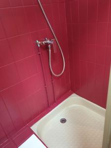 y baño rojo con bañera y ducha. en Eoz an avel, en Combourg