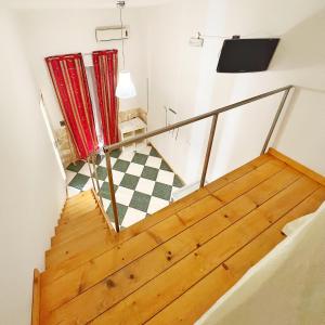 uma vista para uma escada com pisos em madeira e uma televisão em Pantalica Rooms Affittacamere em Sortino