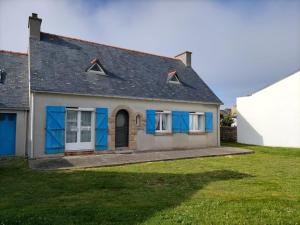 ein Haus mit blauen Türen und einem Rasenplatz in der Unterkunft Trouz Ar Mor in Penmarcʼh