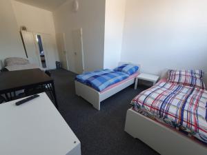 Habitación con 2 camas, mesa y escritorio. en Akdeniz Pension en Ludwigsfelde