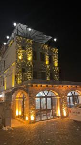 um grande edifício com luzes acesas à noite em Balloon View Hotel em Goreme