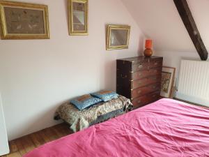 ein Schlafzimmer mit einem rosa Bett und einer Kommode in der Unterkunft Eoz an avel in Combourg