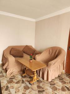 een woonkamer met een bank en een tafel bij Guesthouse TTT-1 in Tbilisi City