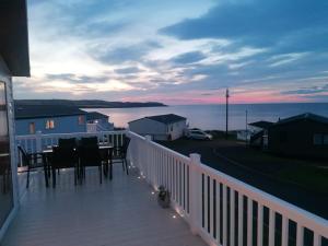 a deck with a table and chairs on a balcony at Lovely 3-Bed Lodge in Eyemouth with stunning views in Eyemouth