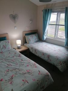 a bedroom with two beds and a window at Lovely 3-Bed Lodge in Eyemouth with stunning views in Eyemouth