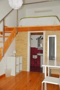a room with a loft bed and a kitchen at Pantalica Rooms Affittacamere Sortino Siracusa in Sortino +10 photos