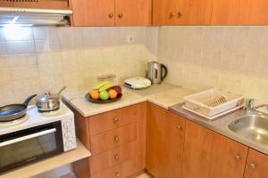 a kitchen with a sink and a bowl of fruit at Terra Olivae Syros in Ermoupoli